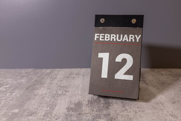 calendar displaying FEBRUARY 12 with light grey background.