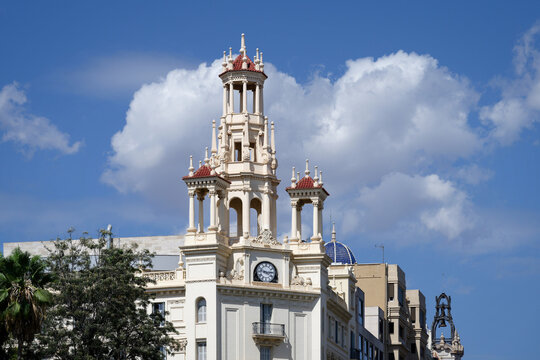 The iconic white ornate tower of Casa del Chavo building under a bright blue sky at Plaza del Ayuntamiento, Valencia