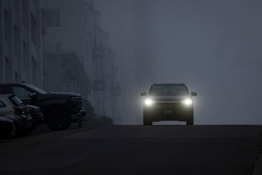 Car with headlights faces camera