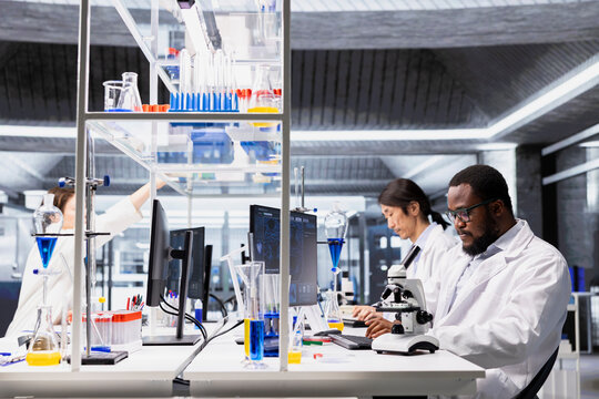 Laboratory scientist using computer software to process DNA patient data for clinical research. Research facility specialist uses PC program to do lab genetic analysis diagnostics - Powered by Adobe