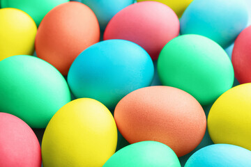 Many painted Easter eggs on light blue background, closeup