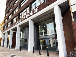 Naklejka premium St James House main entrance in Salford UK with glass doors and brick facade
