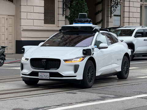 Waymo autonomous Jaguar I-PACE equipped with roof-mounted lidar sensors drives across San Francisco cable car tracks - San Francisco, California, USA - December 25, 2025