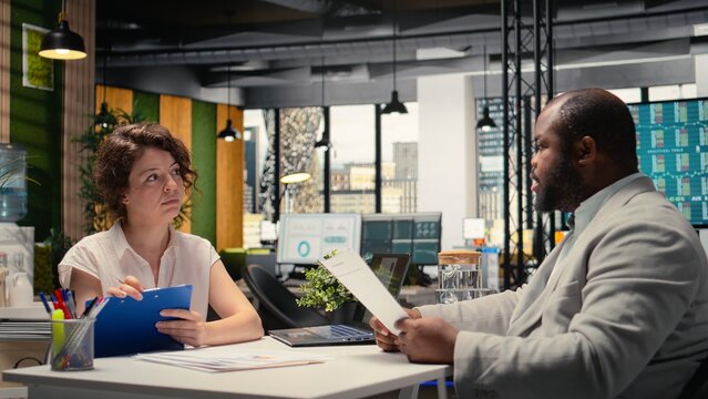 Human resources recruiter evaluating a confident male candidate during a professional job search conversation about employment and onboarding within a growing enterprise. Head hunting. Camera A.