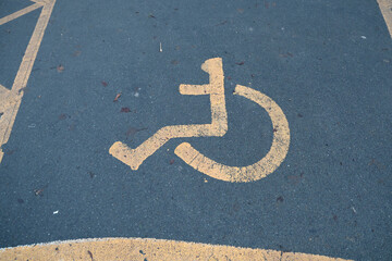 Yellow Disabled Parking Symbol on Asphalt Tarmac Surface