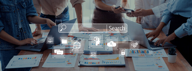 A diverse team collaborates in a modern office environment, utilizing laptops and digital tools to search and analyze data, fostering creativity and productivity in their projects. Trope