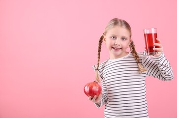Little girl with glass of pomegranate juice and fruit on pink background. Space for text