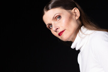 Serious woman looking sideways in dramatic low key portrait
