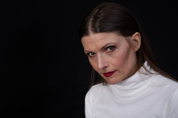 Intense woman staring at camera against dark background
