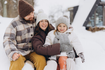 Happy family enjoying winter vacation in snowy nature