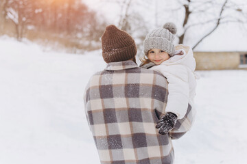 Father carrying daughter playing in winter snow