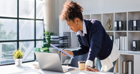 Business in afro hair discussing financial reports and marketing charts during corporate meeting, focusing on strategy, planning, data analysis, on laptop at office