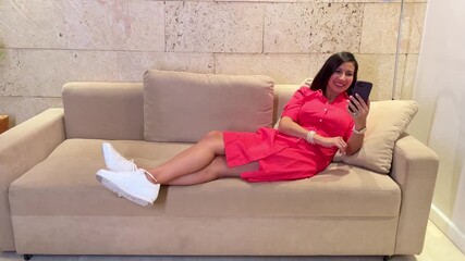 Cheerful Woman Using Phone for Social Media While Lounging on Sofa