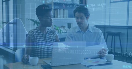 Reviewing two wearing check-top, blue-shirt checking charts on laptop in office with data overlay