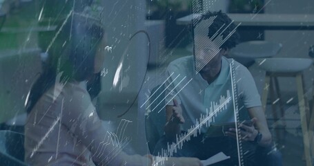 Reviewing tablet and papers, two pros in business casual meeting in office with glass data overlay