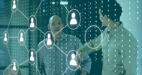 Listening man at center wearing business-casual shirt in office, watching glass network overlay