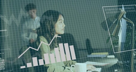 Working woman in light blazer typing at office desk with monitor, mug, papers, data overlay