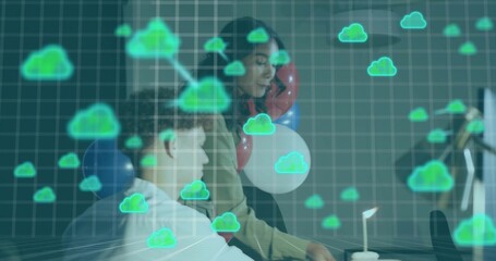 Working colleagues wearing workwear leaning toward monitor at office, with cloud overlay, balloons