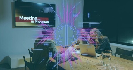 Discussing project at meeting table, three team wearing business attire pointing at laptop hologram