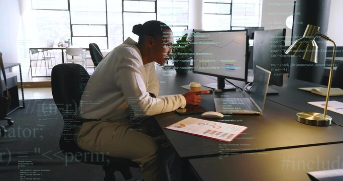 Working mature man in white long-sleeve shirt typing on laptop at open-plan office, with charts - Powered by Adobe