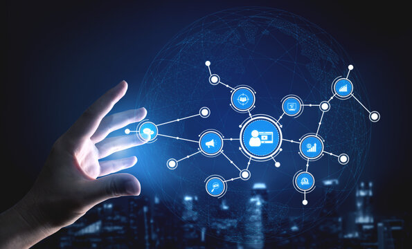 A human hand reaches toward glowing digital network symbols, representing the convergence of technology and human interaction in a futuristic urban landscape. Tessel - Powered by Adobe