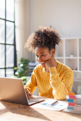Beautiful African american in afro hair business woman working with financial documents in modern...