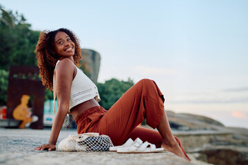 Young woman smiling, relaxing outdoors during summer travel. She is experiencing freedom and happiness on her vacation © we.bond.creations
