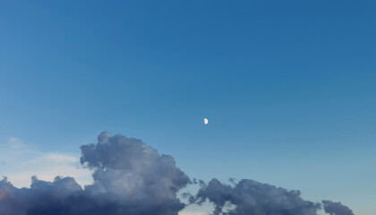 Obraz premium Luna di giorno nel cielo sopra le nuvole