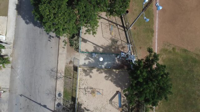 Drone 4K top-down aerial view of an empty children&rsquo;s playground inside a neighborhood park. The scene focuses on outdoor recreational spaces, urban greenery and healthy environments that support wellb