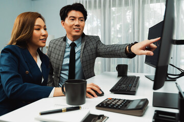 Asian business partners pointing to profit highest dynamic stock exchange data on computer screen value rate online website program. Investor showing financial on real time at modern office. Infobahn.