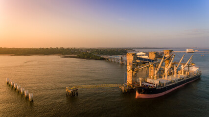 Amazonian Sunrise over soybean bulk carrier at Itupanema port in Barcarena, Amazon, Brazil