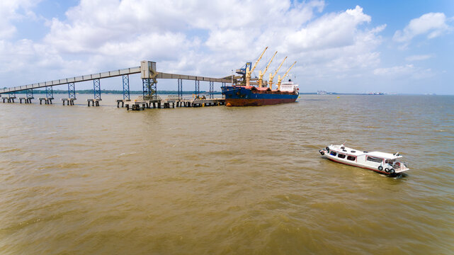 Contrast between local boat and soybean bulk carrier in Barcarena port, Amazon, Brazil