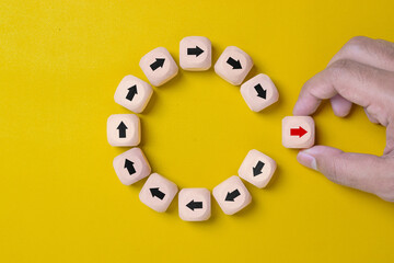 Disruption and technology transformation concept , Hand move out red arrow on wooden block cube move out from circle black arrow on yellow background