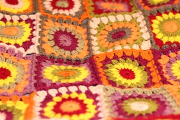Granny square crocheted blanket with different colors motives, retro vintage craft handmade handiwork crocheting, beautiful plaid photo cozy winter or autumn background wool thing yarn warm bohemian