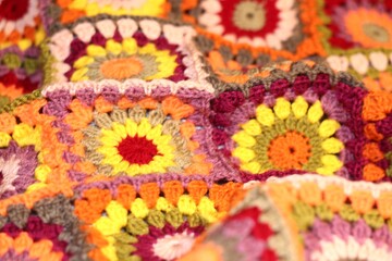 Granny square crocheted blanket with different colors motives, retro vintage craft handmade handiwork crocheting, beautiful plaid photo cozy winter or autumn background wool thing yarn warm bohemian