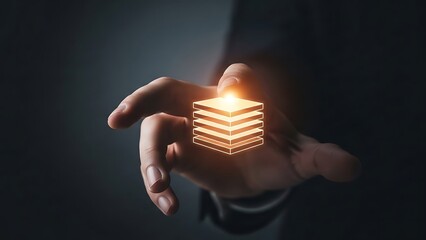 hand holding glowing orange layered rectangle icon on dark background  technology concept
