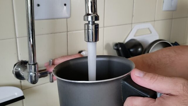 person filling a pot with water - pessoa enchendo uma panela com &aacute;gua