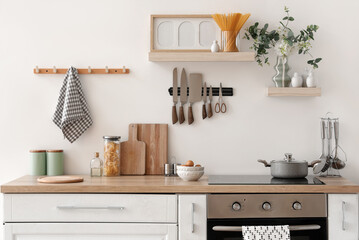 Interior of kitchen with counter, shelves and knives