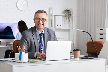 Male business analyst working with laptop at desk in office. Data science concept