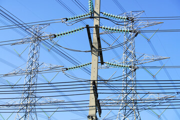 High Voltage Power Lines Under Clear Blue Sky Connecting Infrastructure