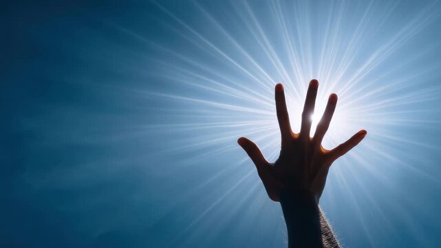 Hand silhouette reaching radiant halo light with blue sky background, symbolizing hope, aspiration, and spiritual connection bright sunlight