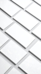 Obraz premium Multiple blank white rectangular cards arranged in a grid pattern on a light grey surface, creating a clean and minimalist background.