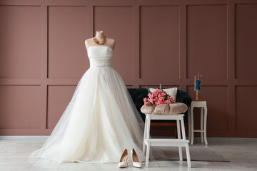 Interior of room with wedding dress, sofa and stool