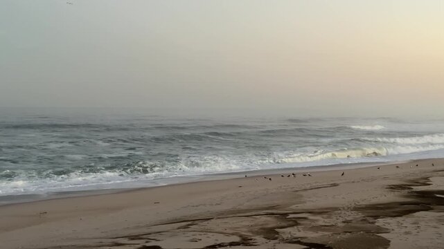Beach-breaking waves breaking to the shore at sunset . Copy-Space.