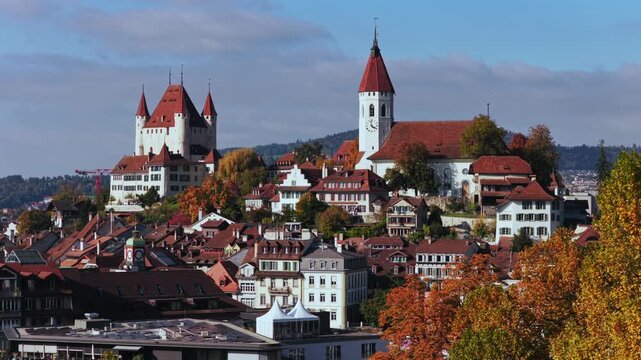 Autumn Fall Thun Castle Schloss Thun Switzerland Schweiz aerial drone parallax Thunersee blue sky clouds sunny golden yellow colorful beeches birches tree Aare River Bernese Oberland circle right