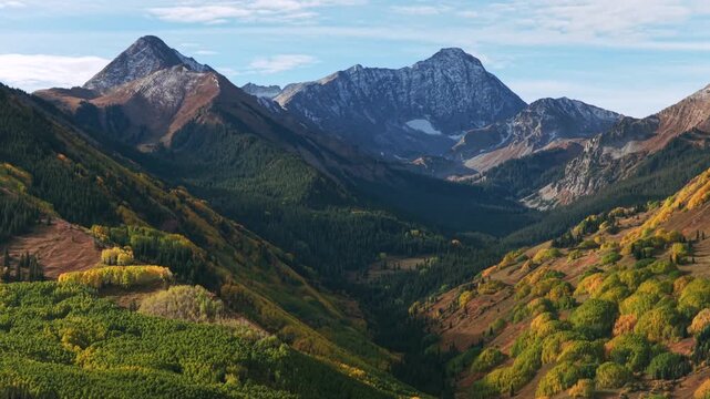 Morning sunny blue sky snowy 14er Capitol Peak creek trail wilderness Aspen Snowmass Colorado aerial drone green aspen trees grove White River Forest Elk Range Rocky Mountains forward pan up motion