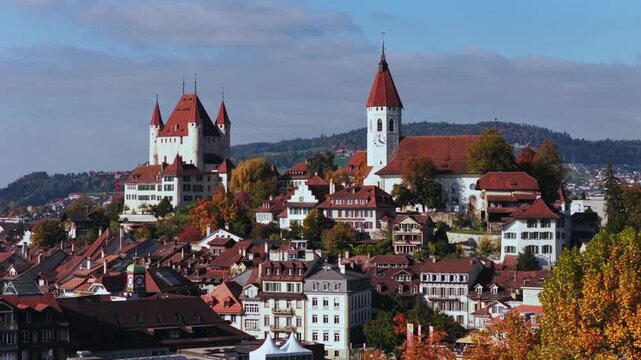 Autumn Fall Thun Castle Schloss Thun Thunersee Switzerland Schweiz Europe aerial drone parallax blue sky clouds sunny golden yellow beeches birches tree Aare River Bernese Oberland circle right motion
