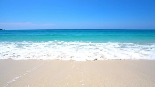A serene ocean view with waves crashing on a sandy beach under a clear blue sky