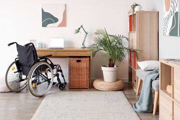 Interior of light office with shelf unit, workplace and wheelchair