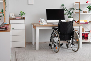 Interior of light office with workplace and wheelchair